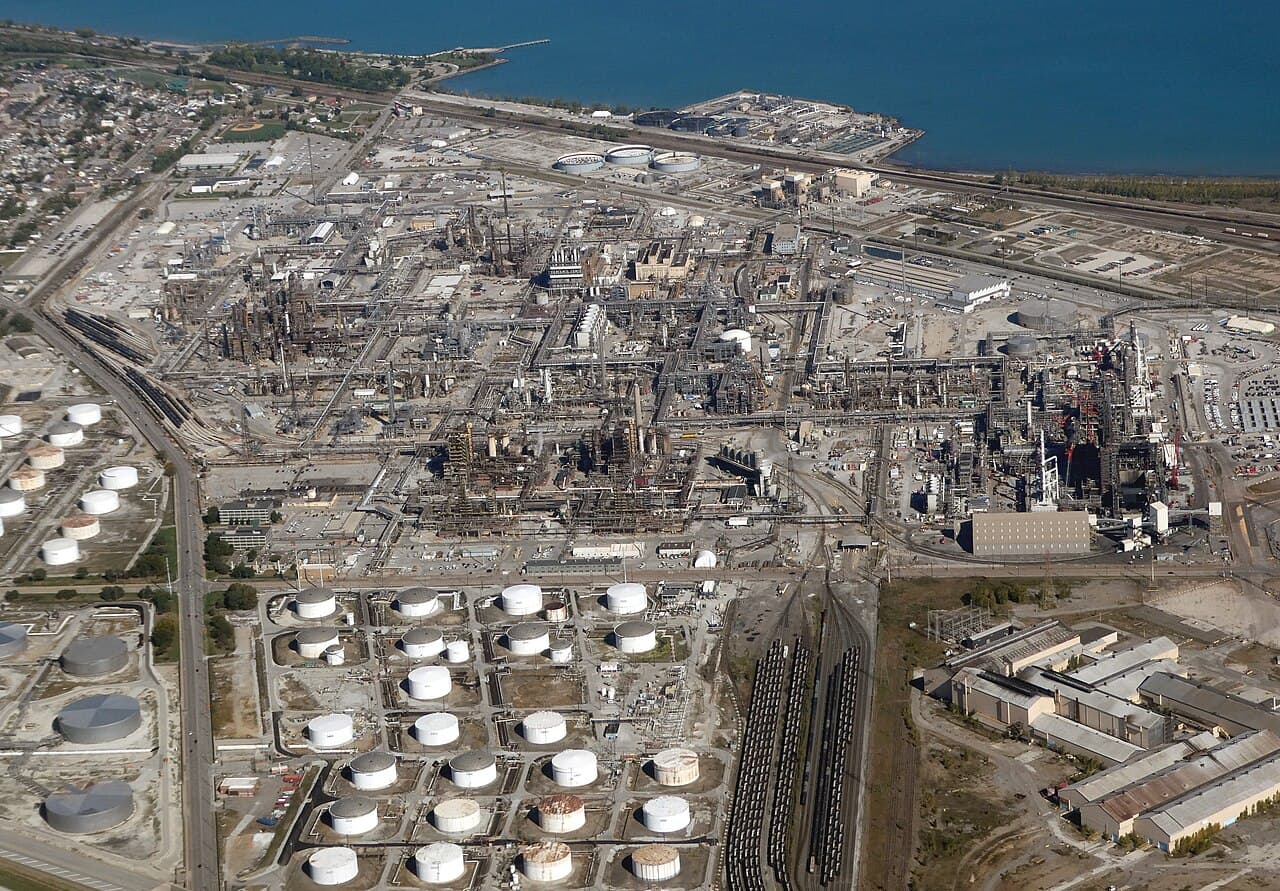 Aerial view of oil storage tanks and processing equipment at Whiting Refinery beside Lake Michigan.